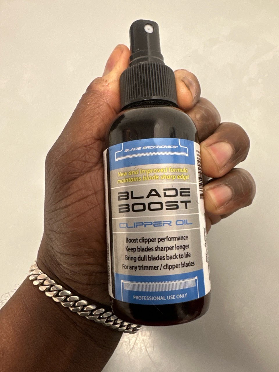 Hand holding Blade Boost Clipper Oil